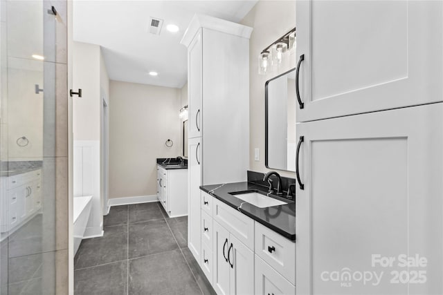 bathroom featuring baseboards, visible vents, two vanities, a sink, and tile patterned floors