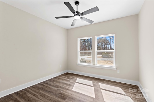 empty room featuring dark wood-style floors, a ceiling fan, and baseboards