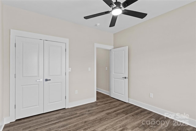 unfurnished bedroom featuring a closet, baseboards, wood finished floors, and a ceiling fan