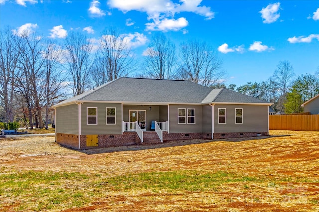 ranch-style home featuring crawl space, a porch, a shingled roof, and fence