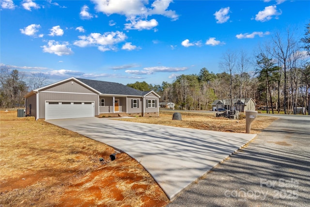 view of front facade with a porch, central air condition unit, concrete driveway, and an attached garage