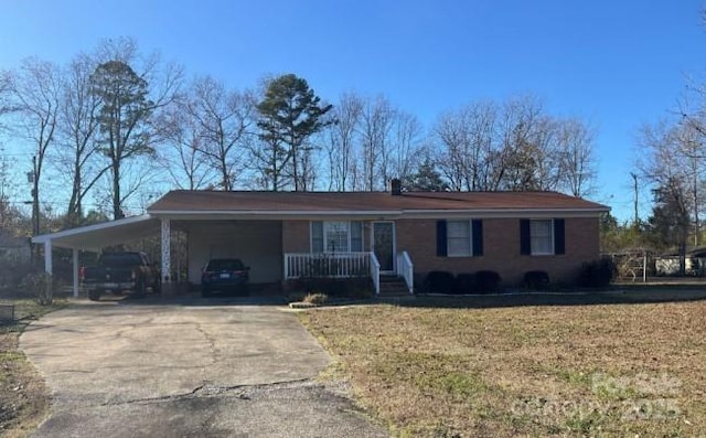 view of front of property with covered porch, an attached carport, driveway, and a front yard