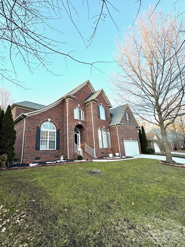 view of front of home featuring brick siding, a garage, driveway, and a front yard