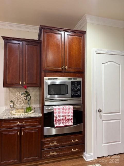 kitchen with light stone counters, ornamental molding, tasteful backsplash, and stainless steel appliances