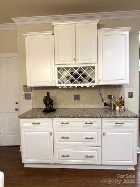 bar featuring decorative backsplash, dark wood-style flooring, and crown molding