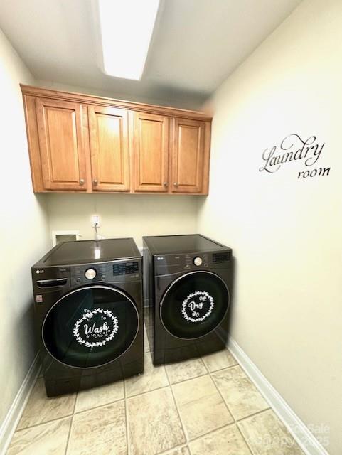 washroom with light tile patterned floors, cabinet space, independent washer and dryer, and baseboards