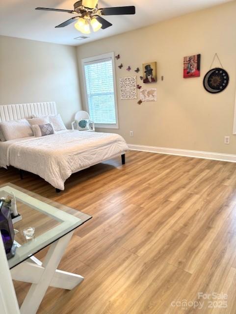 bedroom with light wood-style flooring, baseboards, and ceiling fan