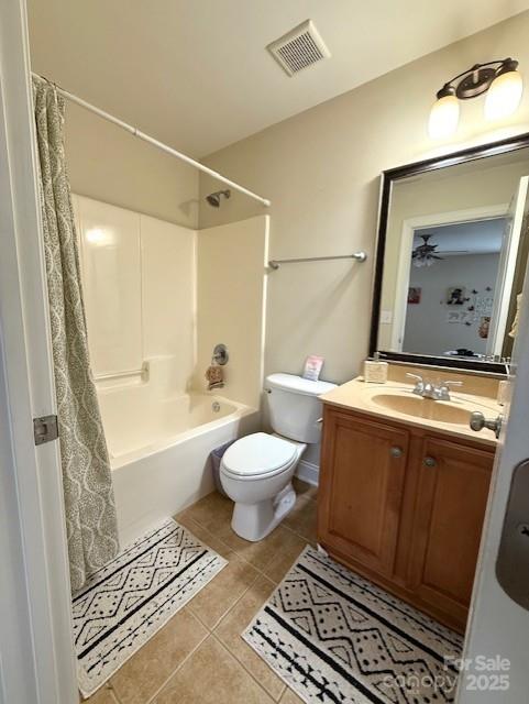 bathroom with tile patterned floors, visible vents, toilet, shower / tub combo, and vanity