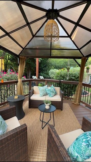 wooden terrace with a gazebo and outdoor lounge area