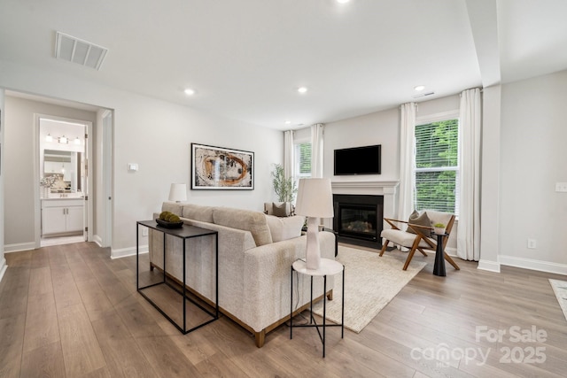 1439 Hubert Graham Way, Tega Cay, SC 29708 - living room featuring wood finished floors, a fireplace with flush hearth, baseboards, and recessed lighting