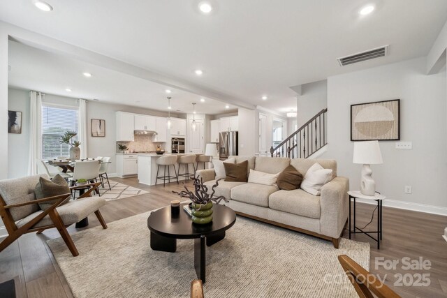 1439 Hubert Graham Way, Tega Cay, SC 29708 - living room with recessed lighting, light wood-type flooring, stairs, and baseboards