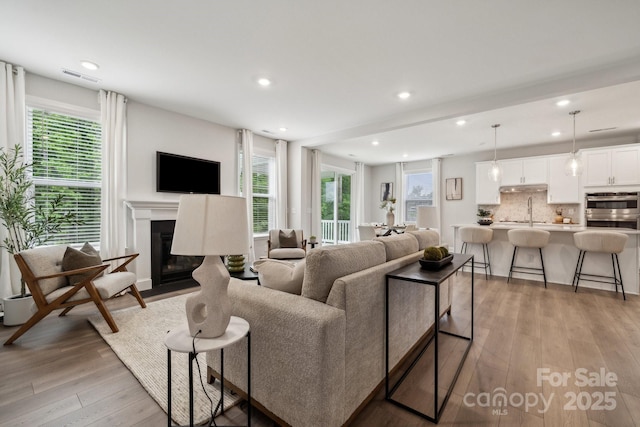 1439 Hubert Graham Way, Tega Cay, SC 29708 - living area with light wood-style flooring, healthy amount of natural light, recessed lighting, and a fireplace with flush hearth