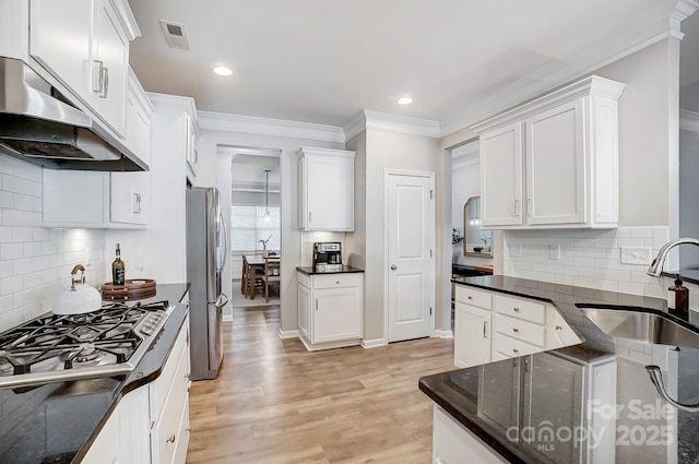 kitchen with under cabinet range hood, stainless steel appliances, a sink, and tasteful backsplash