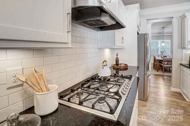 kitchen featuring exhaust hood, ornamental molding, white cabinetry, backsplash, and appliances with stainless steel finishes