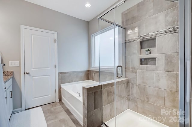 bathroom featuring vanity, a bath, and a stall shower