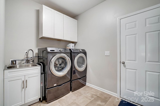 clothes washing area featuring baseboards, cabinet space, a sink, and washer and clothes dryer