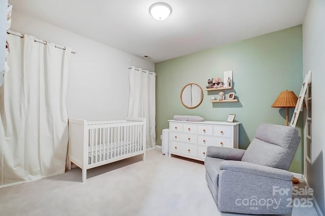 carpeted bedroom with baseboards and a crib