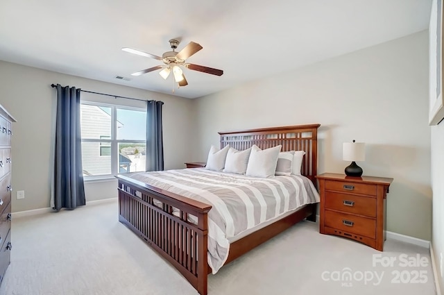 bedroom featuring light colored carpet, visible vents, baseboards, and a ceiling fan
