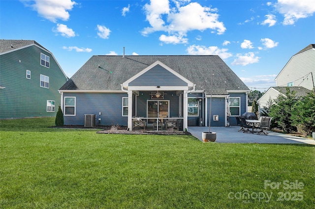 back of property with cooling unit, a patio, a sunroom, a shingled roof, and a yard