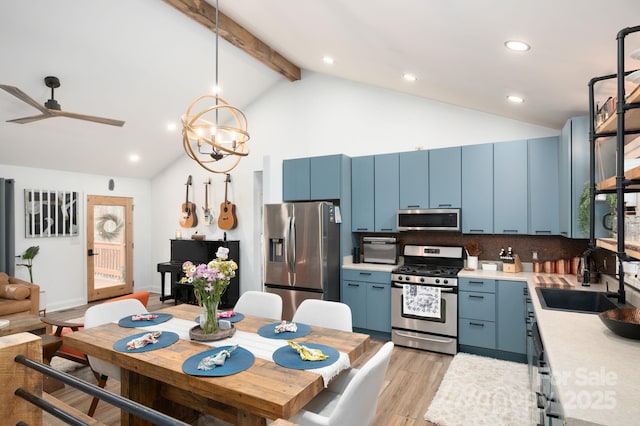 kitchen with blue cabinetry, beamed ceiling, light countertops, appliances with stainless steel finishes, and a sink