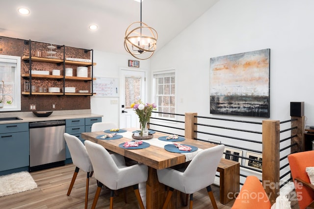 dining space featuring vaulted ceiling, a notable chandelier, recessed lighting, and light wood-type flooring