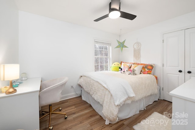 bedroom featuring ceiling fan, a closet, baseboards, and wood finished floors