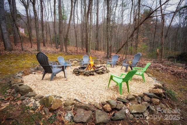 view of yard with a fire pit and a forest view