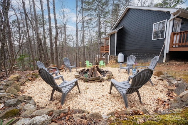 view of yard with a deck and an outdoor fire pit