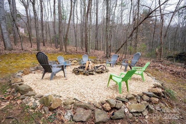 view of yard with a fire pit and a forest view