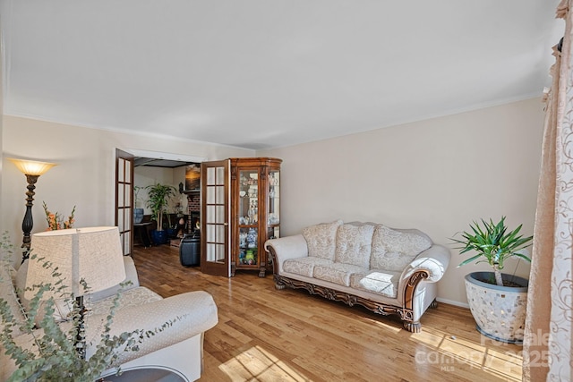 living room featuring french doors, crown molding, and wood finished floors