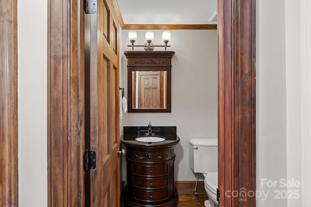 bathroom with toilet, wood finished floors, and vanity