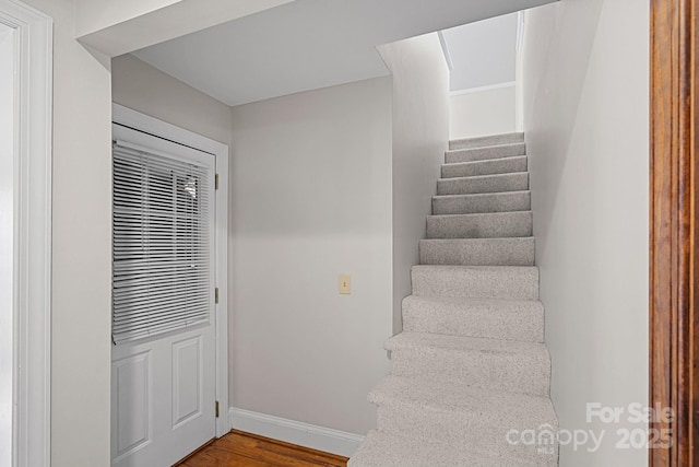 stairway featuring wood finished floors and baseboards