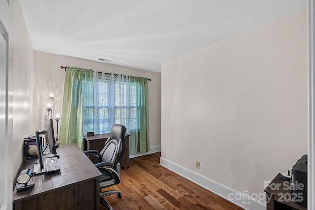 office area featuring visible vents, baseboards, and wood finished floors