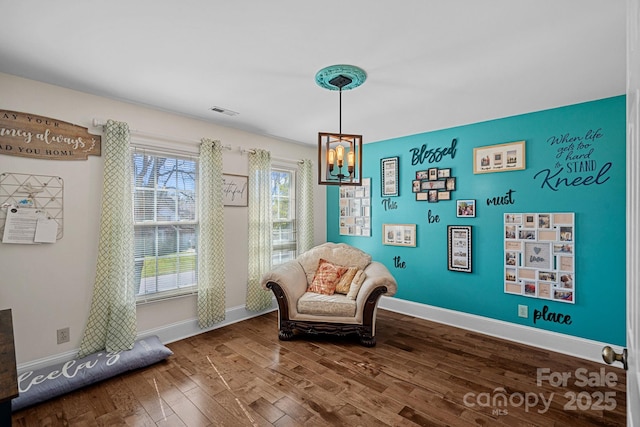 living area with dark wood finished floors, an inviting chandelier, visible vents, and baseboards