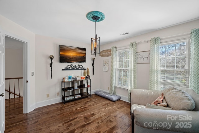 living area featuring wood finished floors, visible vents, and baseboards