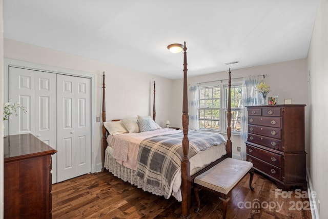 bedroom with a closet, visible vents, and dark wood finished floors