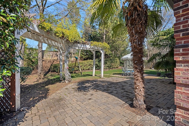 view of patio featuring a pergola and fence