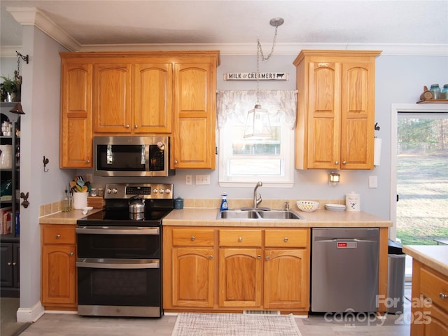 kitchen with ornamental molding, stainless steel appliances, light countertops, and a sink