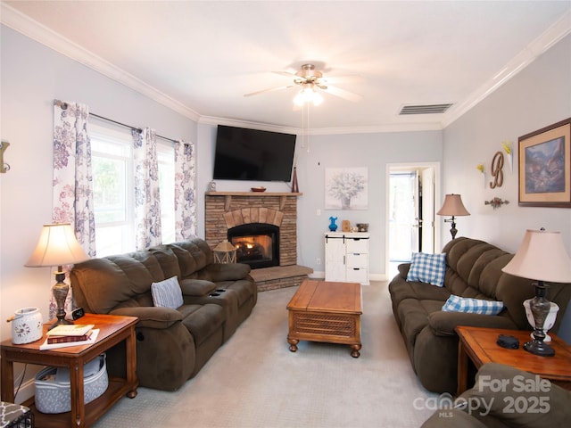 living room with visible vents, carpet, a stone fireplace, and ornamental molding