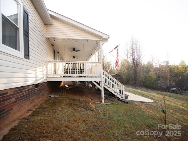 exterior space featuring stairway, a lawn, and ceiling fan