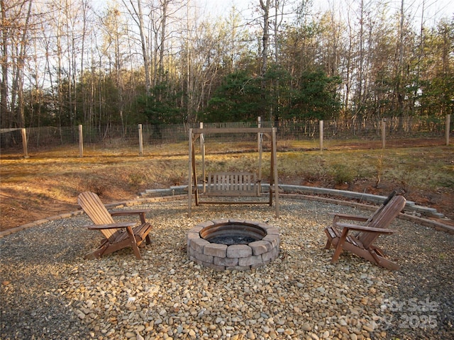 view of yard with a gate, an outdoor fire pit, and fence