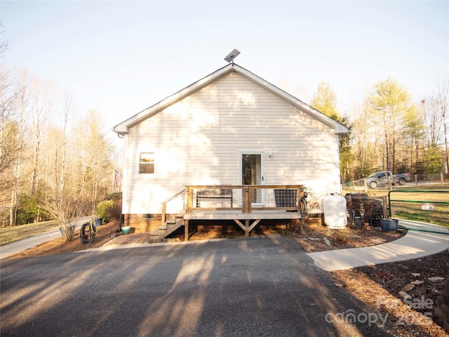 rear view of property with a deck and fence