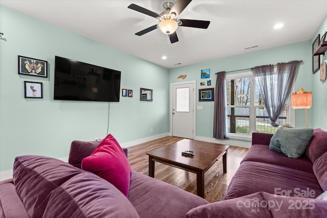 living area featuring a ceiling fan, wood finished floors, visible vents, baseboards, and recessed lighting