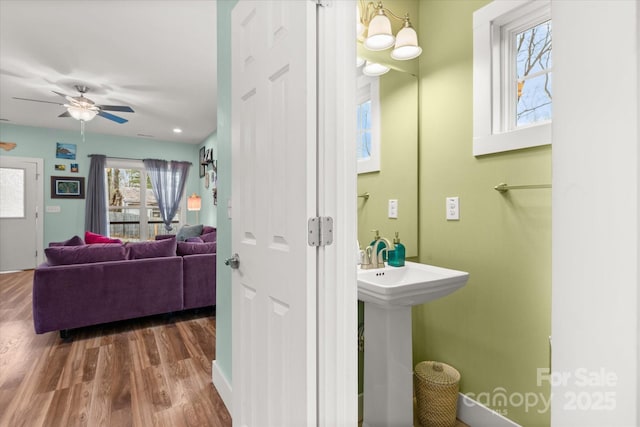 bathroom featuring ceiling fan, wood finished floors, and a sink