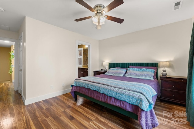 bedroom featuring visible vents, connected bathroom, ceiling fan, baseboards, and wood finished floors