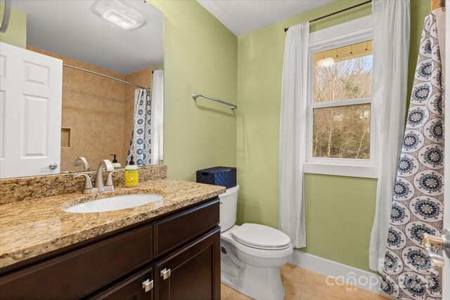 full bath featuring tile patterned floors, a shower with curtain, toilet, and vanity