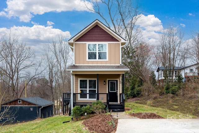 view of front of house with a porch, a front lawn, and board and batten siding