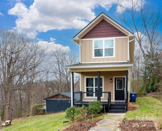 view of front facade with a porch, a front lawn, and board and batten siding