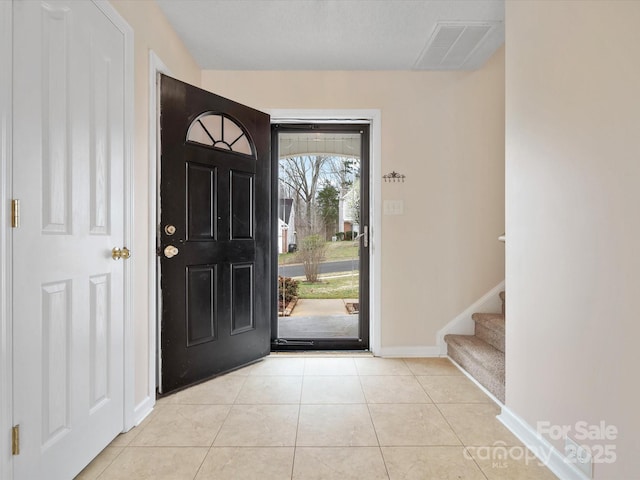 tiled foyer entrance with stairway, baseboards, and visible vents