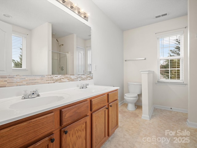 bathroom featuring a shower stall, toilet, tasteful backsplash, and a sink